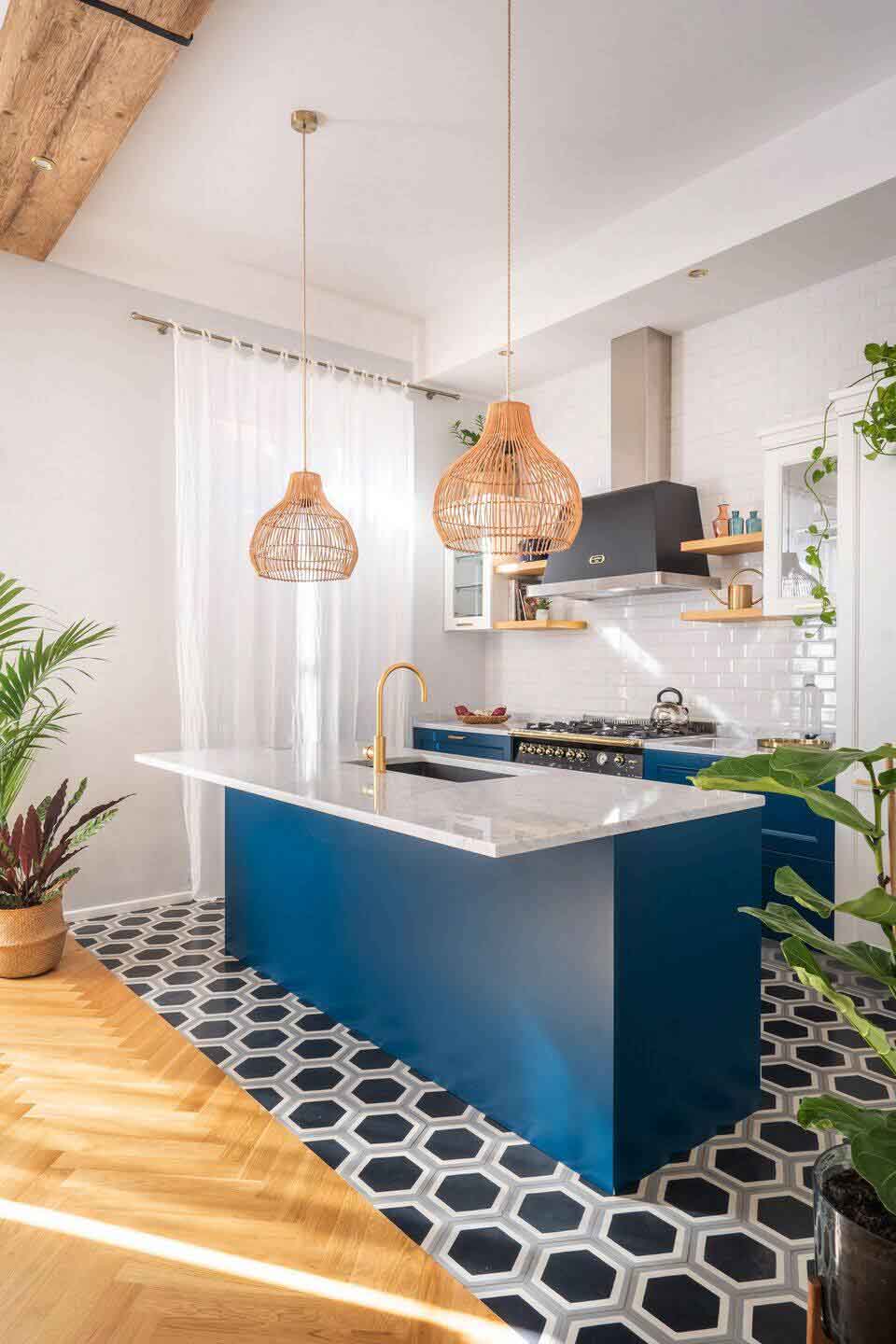 Khu vực bếp nổi bật với hệ tủ bếp màu xanh dương, phối cùng mặt bàn bếp làm từ đá marble trắng